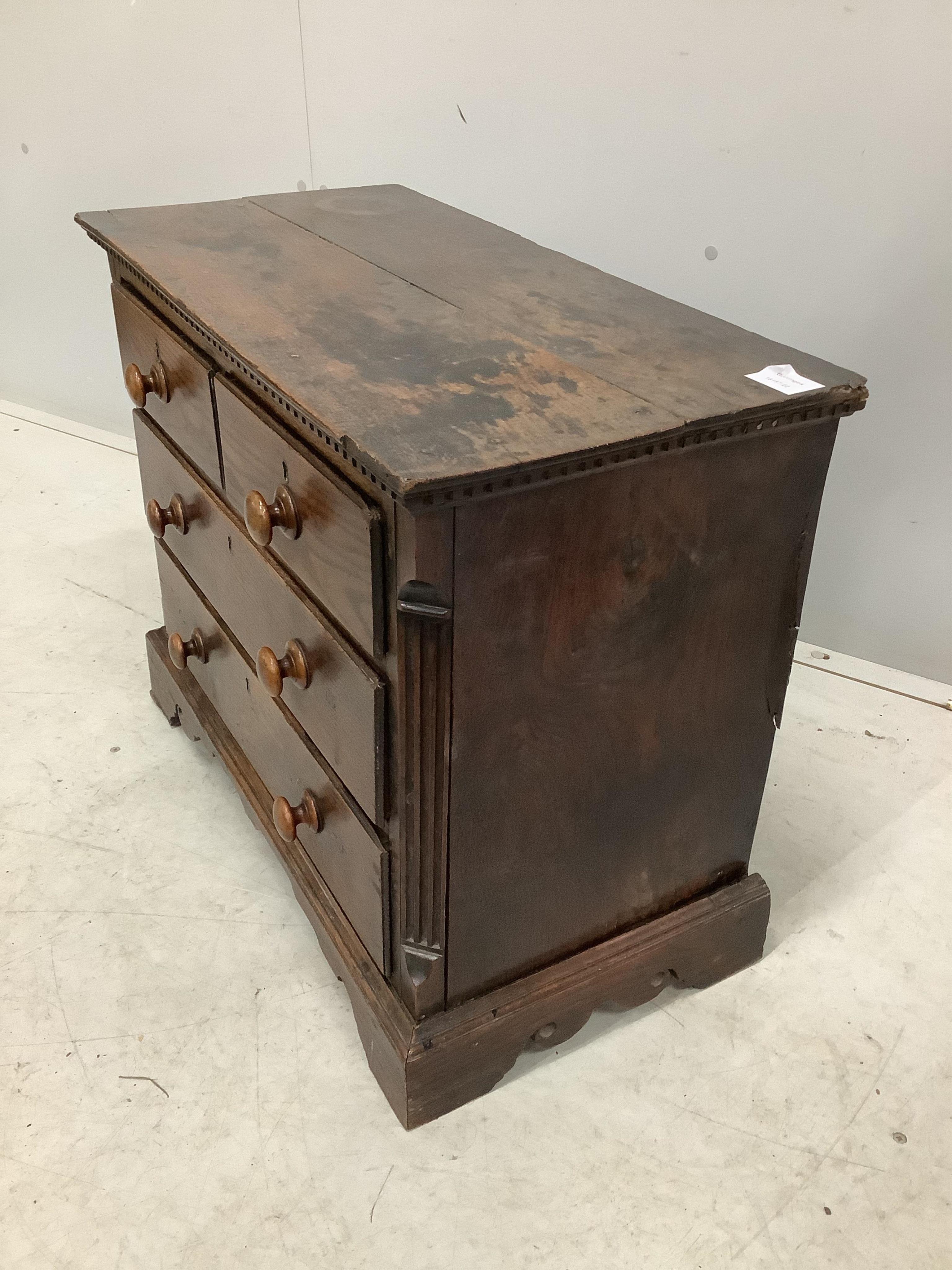 An 18th century miniature oak chest of two short and two long drawers, possibly child’s furniture, width 67cm, depth 34cm, height 55cm. Condition - fair, top timber join separated, one scroll detail missing from right br